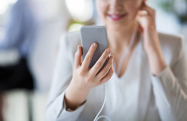 Image showing businesswoman with earphones and smartphone