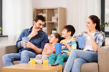 Image showing happy family with popcorn watching tv at home