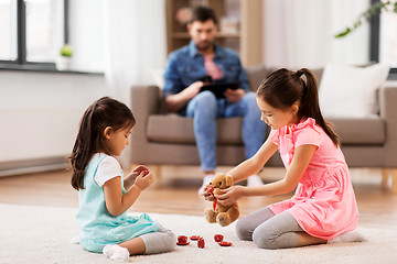 Image showing girls playing with toy crockery and teddy at home