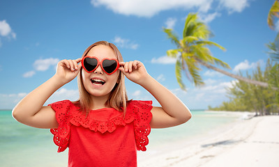 Image showing happy girl with heart shaped sunglasses on beach
