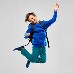 Image showing happy smiling student boy with school bag jumping