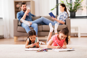 Image showing happy sisters drawing in sketchbooks at home