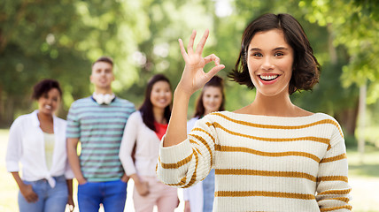 Image showing happy smiling woman showing ok over summer park