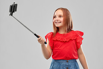 Image showing girl taking picture by smartphone on selfie stick