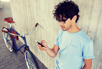 Image showing man with smartphone and fixed gear bike on street