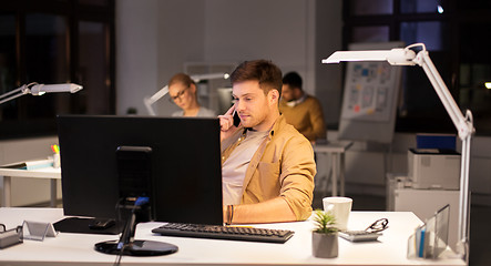 Image showing man calling on smartphone at night office