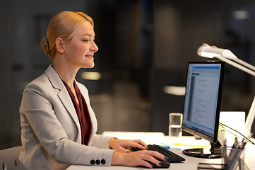 Image showing businesswoman at computer working at night office