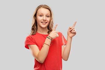 Image showing smiling teenage girl pointing fingers to something