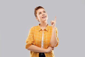 Image showing red haired teenage girl pointing finger up