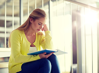 Image showing high school student girl reading book on stairs