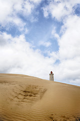 Image showing Lighthouse rising up behind a sand dune