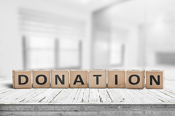 Image showing Wooden donation sign on a worn desk