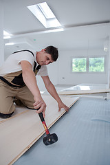 Image showing Professional Worker Installing New Laminated Wooden Floor