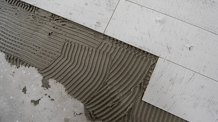 Image showing Ceramic wood effect tiles and tools for tiler on the floor