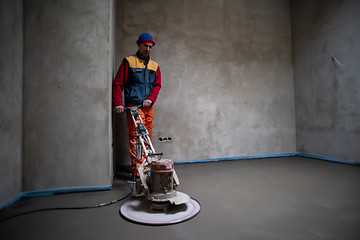 Image showing worker performing and polishing sand and cement screed floor