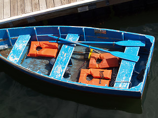 Image showing blue row boat with orange life vests at dock