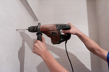 Image showing construction worker drilling holes in the bathroom