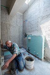 Image showing worker using level tool while installing big ceramic tiles