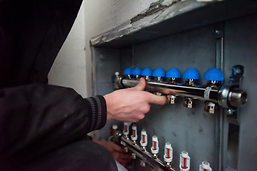 Image showing engineer checking technical data of heating system