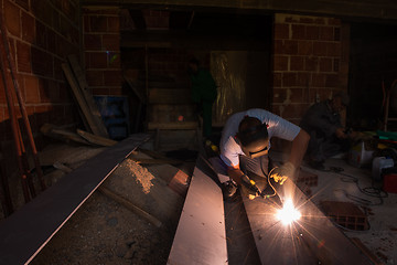 Image showing welder with protective mask welding steel