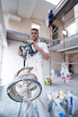 Image showing construction worker mixing plaster in bucket