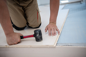 Image showing Professional Worker Installing New Laminated Wooden Floor