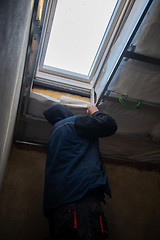 Image showing roofer man installing thermal insulation layer