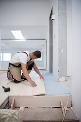 Image showing Worker Installing New Laminated Wooden Floor