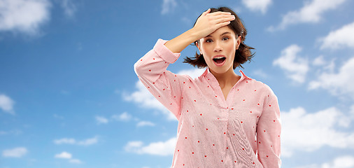 Image showing confused young woman in pajama over sky