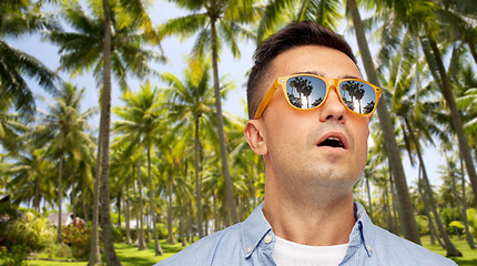 Image showing surprised man in sunglasses over tropical beach