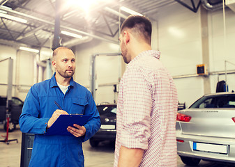 Image showing auto mechanic with clipboard and man at car shop