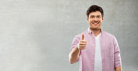 Image showing man showing thumbs up over grey concrete wall