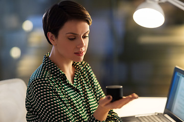 Image showing businesswoman using smart speaker at night office