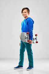 Image showing smiling boy in blue hoodie with skateboard