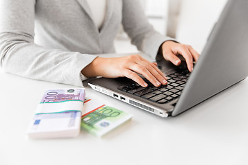 Image showing close up of businesswoman with laptop and money