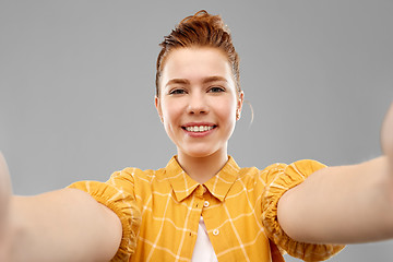 Image showing smiling red haired teenage girl taking selfie