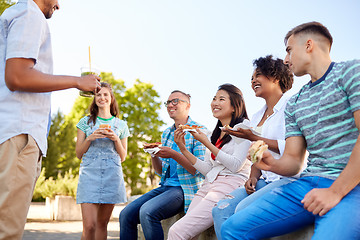 Image showing friends eating sandwiches or burgers in park