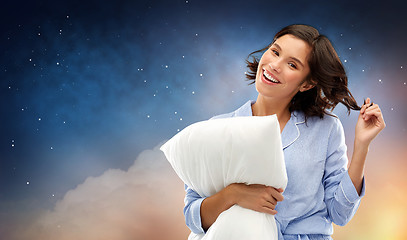 Image showing happy woman in pajama with pillow over night sky