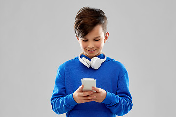 Image showing smiling boy in blue hoodie using smartphone