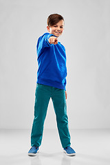 Image showing smiling boy in blue hoodier pointing finger