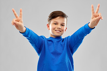 Image showing smiling boy in blue hoodie showing peace gesture