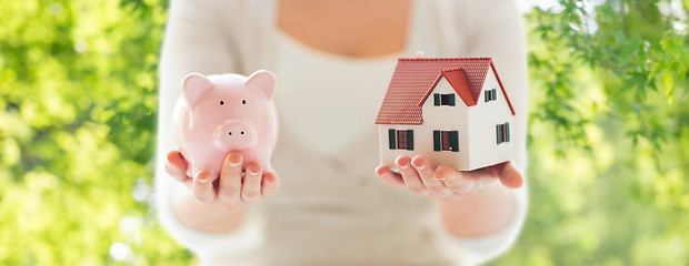 Image showing close up of woman with house model and piggy bank