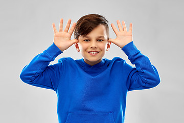 Image showing happy boy having fun and making big ears