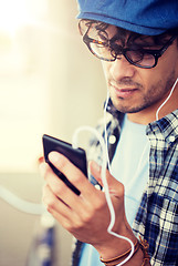 Image showing man with earphones and smartphone listening music