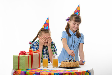 Image showing Girl puts candles on a birthday cake