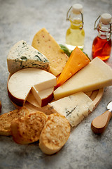 Image showing Various types of cheese served on rustic wooden board