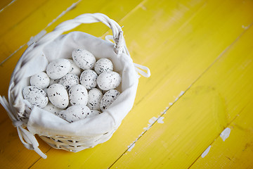 Image showing Quail eggs In white wicker basket. The concept of Easter Holidays