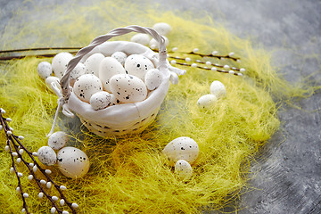 Image showing Easter white dotted Eggs in the nest and spring yellow grass