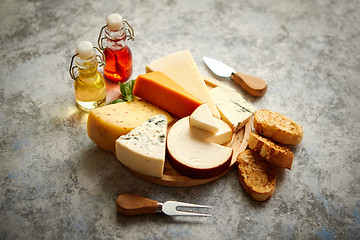 Image showing Various types of cheese served on rustic wooden board