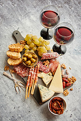 Image showing Cold snacks board with meats, grapes, wine, various kinds of che